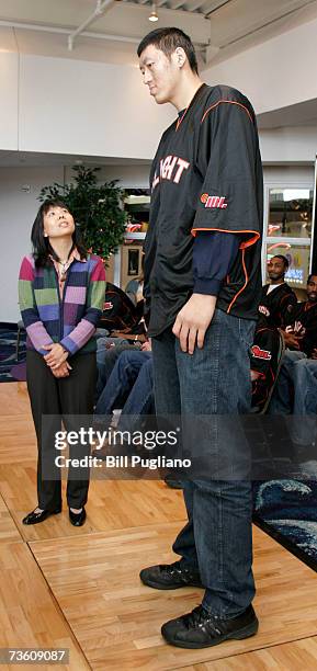 Chinese basketball player Sun Ming Ming stands next to his interpretor Danielle Deng of Grand Rapids, Michigan at a press conference to announce his...