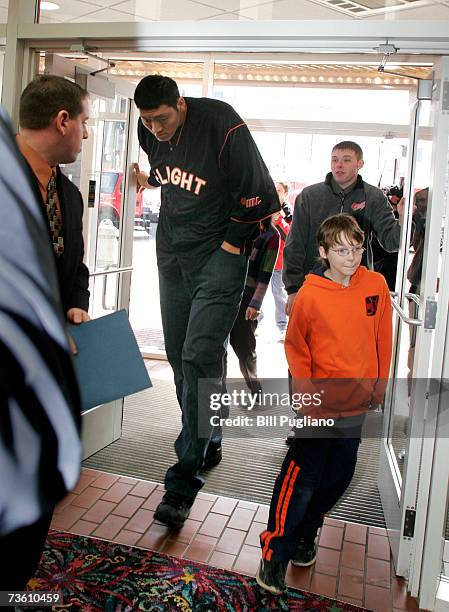 Chinese basketball player Sun Ming Ming ducks as he goes through a doorway on his way to a press conference to announce his signing with the...