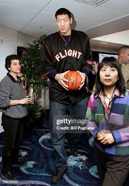 Chinese basketball player Sun Ming Ming exits from a press conference held to announce his signing with the International Basketball League's Grand...