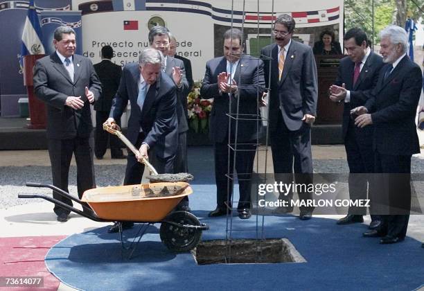 San Salvador, EL SALVADOR: Oscar Berger , presidente de Guatemala, palea cemento durante la ceremonia de colocacion de la piedra fundamental de la...