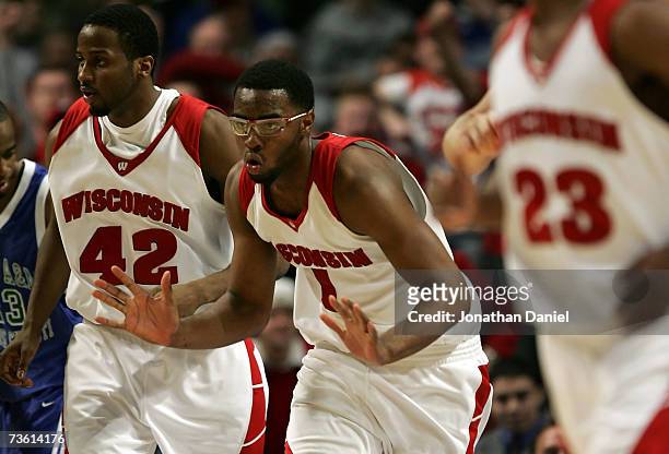 Marcus Landry of the Wisconsin Badgers celebrates as he runs up court with teammates Alando Tucker and Kammron Taylor after Landry made a basket in...