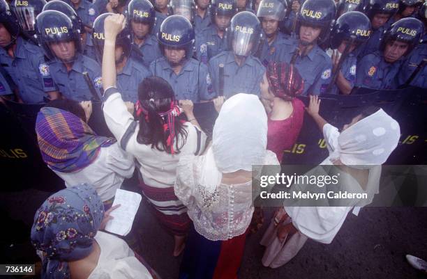 Protesters stands against a team of police as tens of thousands of gather at the historic EDSA Shrine at suburban Mandaluyong for a rally January 17,...