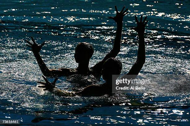 Olivia Allison and Jenna Randall of Great Britain compete in their Duet Technical Preliminary routine of the synchronized swimming event during the...