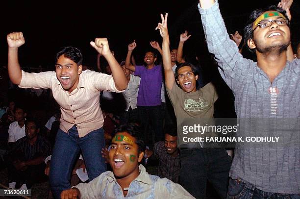 Bangladeshi cricket fans celebrate as they watch a cricket match between Bangladesh and India with a big screen television at university campus in...