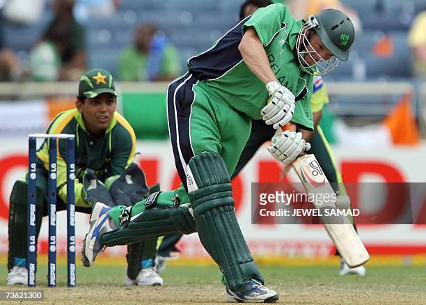 Irish cricketer Niall O'Brien hits a boundary off Pakistani bowler Mohammad Hafeez as wicketkeeper Kamran Akmal looks on during the Group D match of...