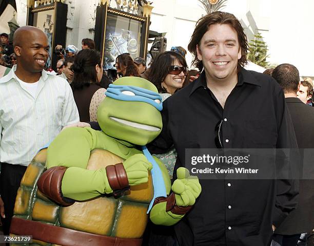 Director Kevin Munroe poses with a Teenage Mutant Ninja Turtle at the premiere of Warner Bros. Picture's Teenage Mutant Ninja Turtles at the Chinese...