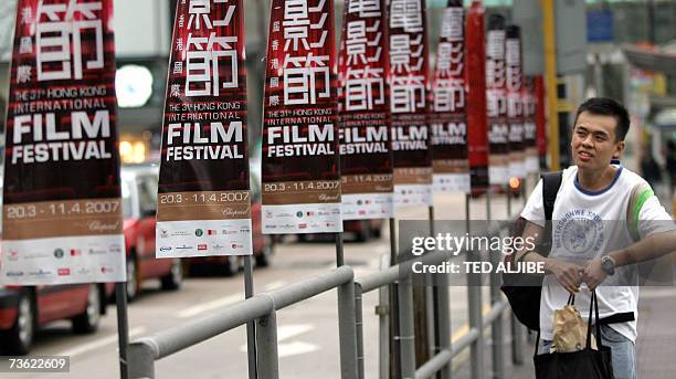 AFPEntertainment-Asia-HongKong-film-awards,sched-ADVANCER A man walks past posters advertising the upcoming Hong Kong International Film Festival ,...