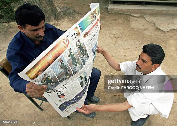 Pakistani men read a newspaper featuring news of the cricket match between Pakistan and Ireland in Islamabad, 18 March 2007. Pakistan cricket team's...