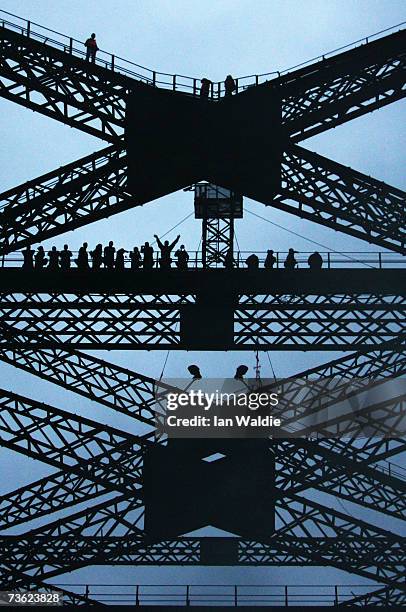 Bridge climbers stand on the superstructure of the Sydney Harbour Bridge during the 75th anniversary celebrations of the opening of the bridge March...