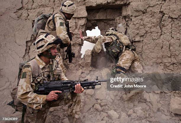 British Marines crawl through a hole after blasting through a wall during a morning anti-Taliban operation on March 18, 2007 near Kajaki in the...