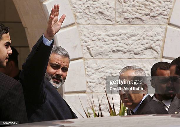 Palestinian Prim Minister Ismail Haniyeh waves while he and the new Finance Minister Sallam Fayad , arrive to the presidental office for the first...