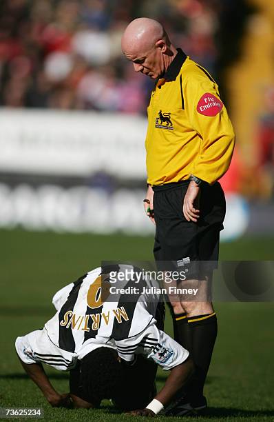 Referee Dermot Gallagher stands over the injured Obafemi Martins of Newcastle United during the Barclays Premiership match between Charlton Athletic...