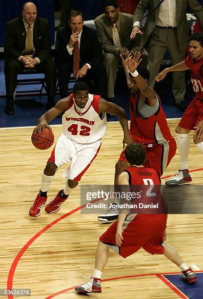 Alando Tucker of the Wisconsin Badgers drives against Kevin Kruger and Wendell White of the UNLV Runnin' Rebels during the second round of the NCAA...