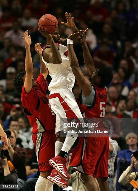 Alando Tucker of the Wisconsin Badgers looks to pass as he is defended by Curtis Terry and Wendell White of the UNLV Runnin' Rebels during the second...