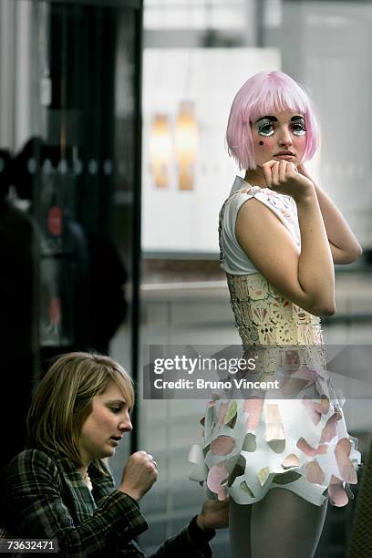 Model wearing a creation by Chelsea College of Art and Design has a last minute alteration made before walking the catwalk at a fashion show during...