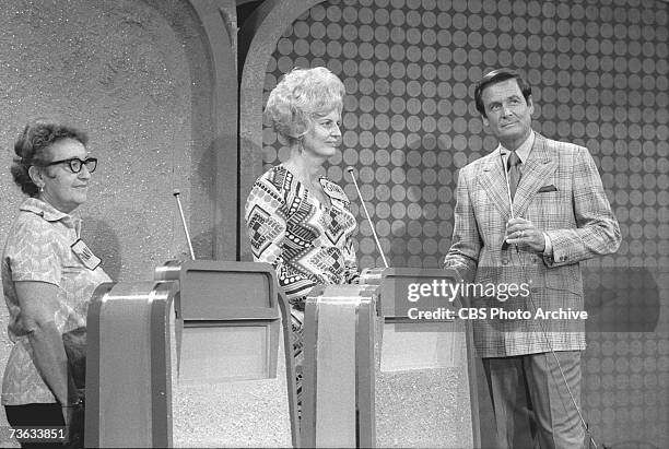 American game show host Bob Barker and two unidentified contestants listen to an unseen announcer during the final 'Showcase Showdown' portion of the...