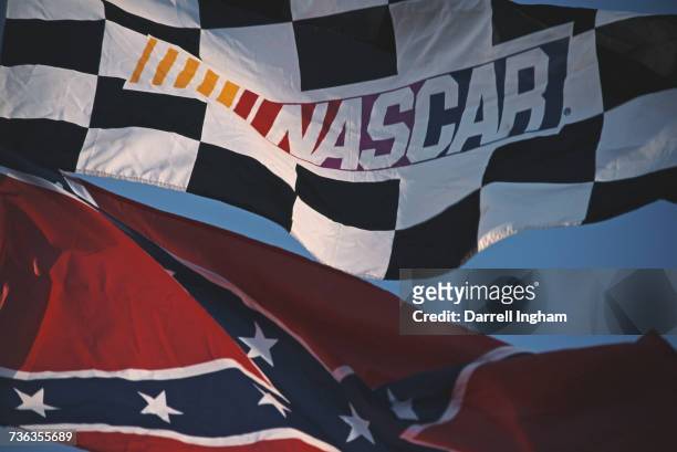 The NASCAR Series flag flies alongside the old Confederate Stars and Bars battle flag during the NASCAR Winston Cup Series Primestar 500 race on 9...