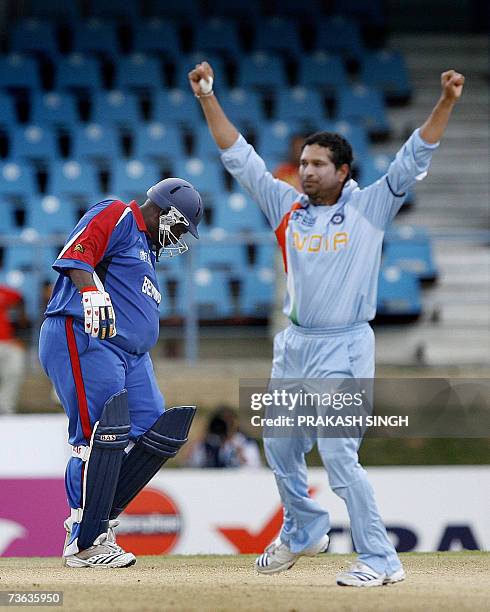 Port-of-Spain, TRINIDAD AND TOBAGO: Bermuda cricketer Dwayne Leverock walks back to the pavillion as India cricketer Sachin Tendulkar celebrates...