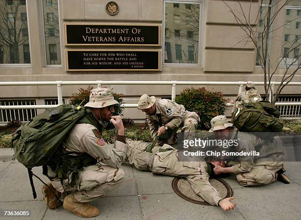 Members of Iraq Veterans Against the War stage a mock sniper shooting of one of their fellow soldiers in front of the Department of Veterans Affairs...
