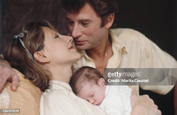 French pop singer and actor Johnny Hallyday with French actress Nathalie Baye and their newborn daughter, Laura, Paris, 15th November 1983.