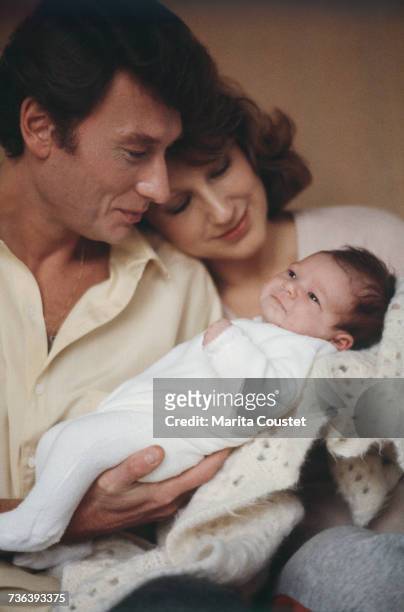 French pop singer and actor Johnny Hallyday with French actress Nathalie Baye and their newborn daughter, Laura, Paris, 15th November 1983.