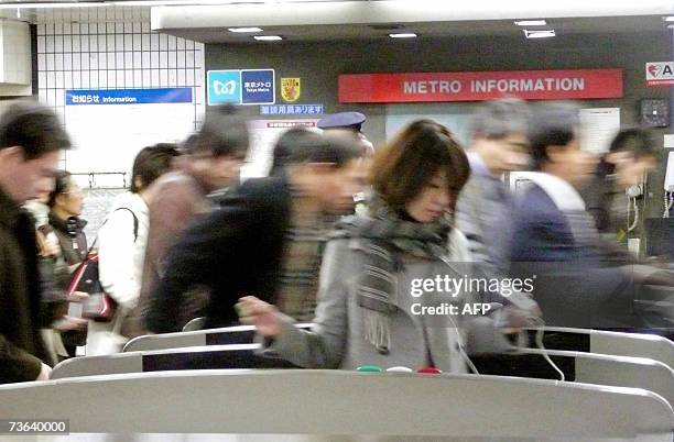 Japanese commuters walk through automated ticket gate of at a Tokyo subway station, 20 March 2007. The Pasmo new rechargeable smartcard, produced by...