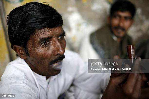 An Indian man exclaims as he exhales smoke after smoking a chillum of hashish at a roadside tea stall in New Delhi, 20 March 2007. Cannabis, also...