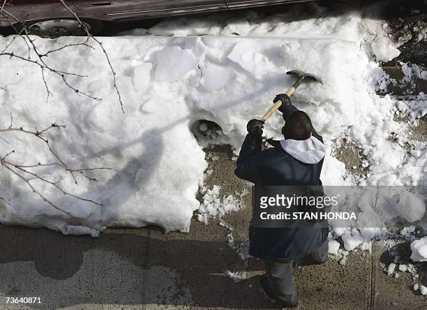 New York, UNITED STATES: On the last day of winter, two workmen clear a Manhattan street of snow 20 March 2007, in New York. The first day of spring,...