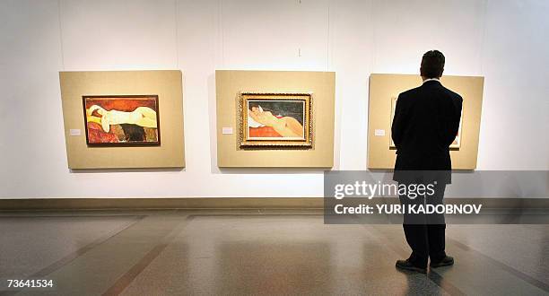 Moscow, RUSSIAN FEDERATION: Picture taken 19 March 2007 shows a visitor looking at paintings during the press viewing of "Meeting Modigliani"...
