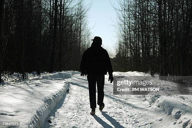 Anchorage, UNITED STATES: Wildlife Biologist for the Alaska Department of Fish and Game Rick Sinnott tracks a moose on a neighborhood trail in...