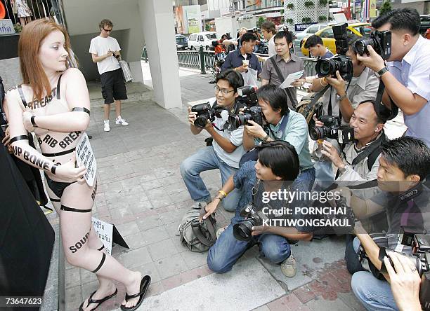 Local photographers take pictures of nude activist Ashley Fruno of Canada holding a banner to protest against eating meat at a shopping mall in...