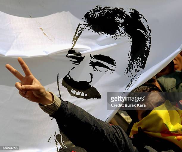 Masked Kurdish demostrator displays an image of jailed Kurdish rebel leader, Abdullah Ocalan, during a gathering to celebrate Newroz March 21, 2007...