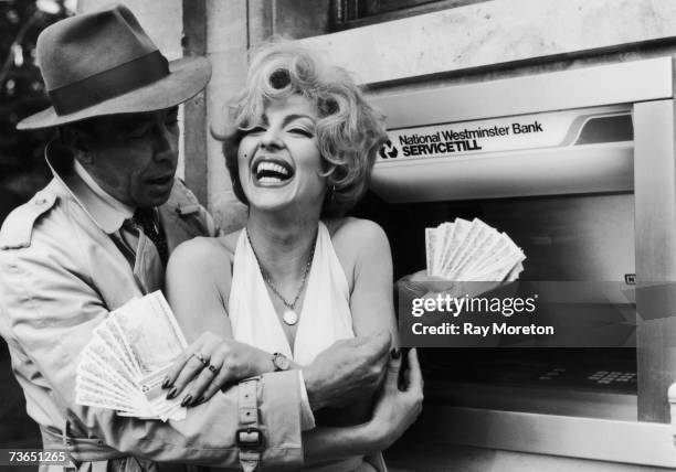 Celebrity lookalikes Vicki Scott and Kenny Whymark withdraw 100 pounds each to inaugurate National Westminster Bank's 500th cashpoint machine,...