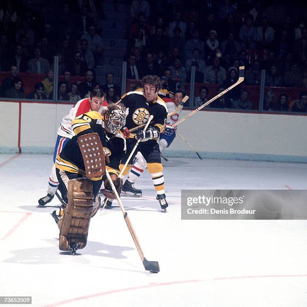 Goaltender Gerry Cheevers of the Boston Bruins attempts to clears the puck against the Montreal Canadiens.