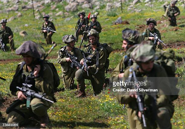 Israeli infantry soldiers from the elite reconnaissance battalion of the Israeli army's Nahal brigade take up positions as they advance against the...