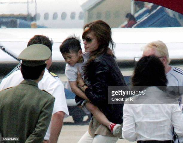 Hollywood movie star Angelina Jolie carries her newly adopted Vietnamese three-year-old son Pax Thien Jolie as she boards a jet at Hanoi's Noibai...
