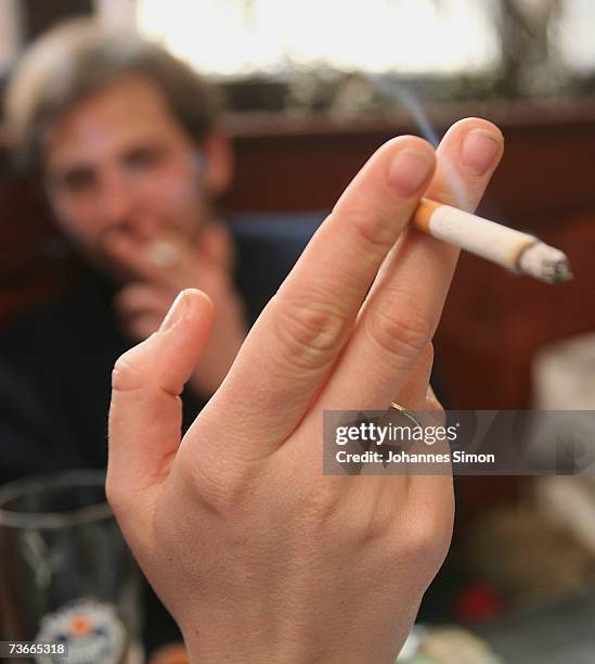 Young people smoke in traditional restaurant "Weisses Braeuhaus", March 22, 2007 in Munich, Germany. German lawmakers are currently wrangling over...