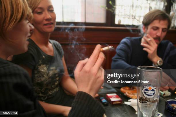 Young people smoke in traditional restaurant "Weisses Braeuhaus", March 22, 2007 in Munich, Germany. German lawmakers are currently wrangling over...