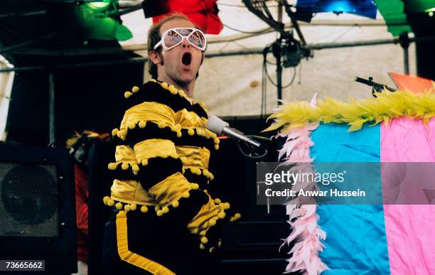 Elton John performs at an open-air concert in May 1974 in Watford, England.