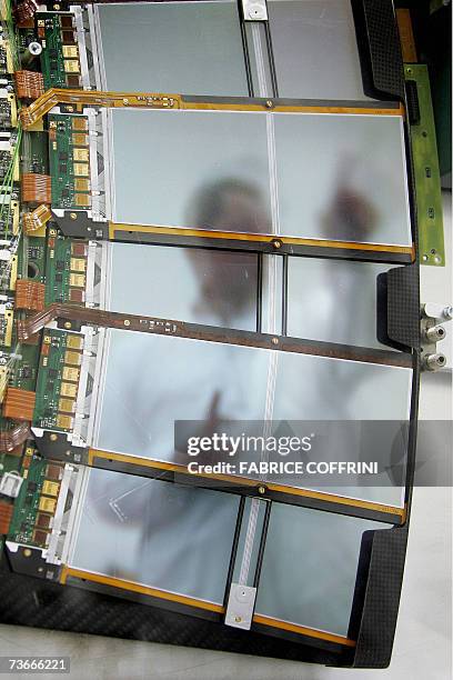 An engineer is seen through silicium sensors, 22 Mars 2007 near Geneva, during the building of the cap of the world's largest superconducting...