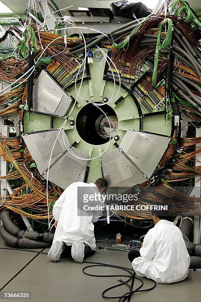 Technicians work 22 Mars 2007 near Geneva, at the building of the cap of the world's largest superconducting solenoid magnet , one of the experiments...