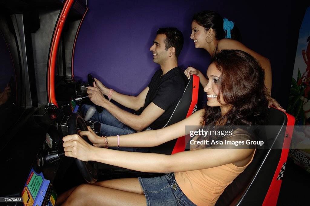 Young adults in a video game arcade, playing games