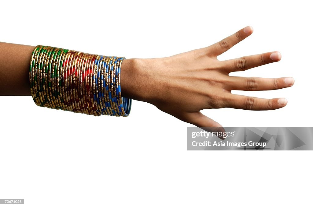 Woman's hand with many bangles on her wrist