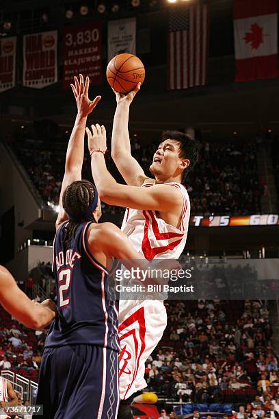 Yao Ming of the Houston Rockets hooks a shot over Josh Boone of the New Jersey Nets at the Toyota Center on March 9, 2007 in Houston, Texas. The...