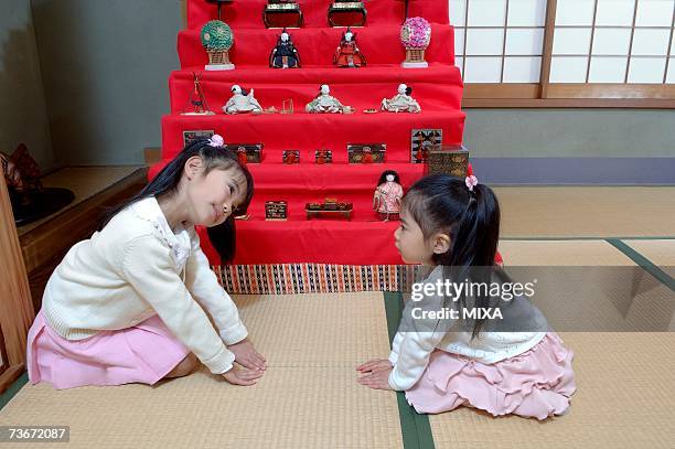 girls bowing in front of dolls - girls day stockfoto's en -beelden