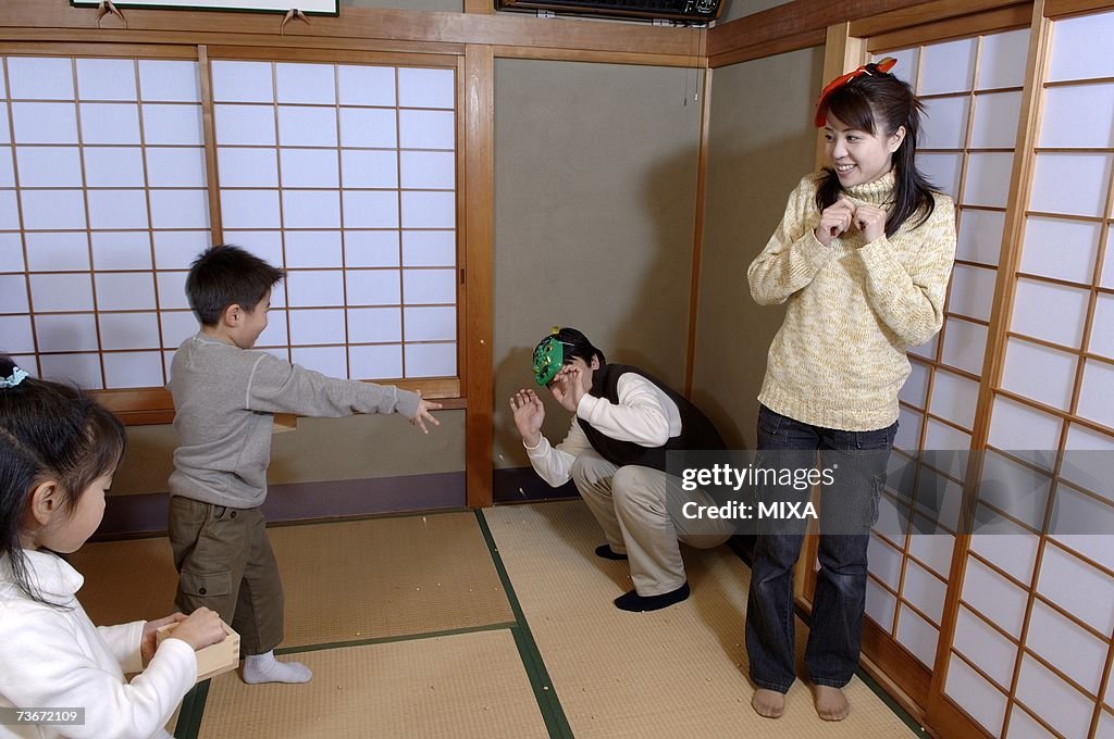 Children throwing roasted beans for setsubun festival