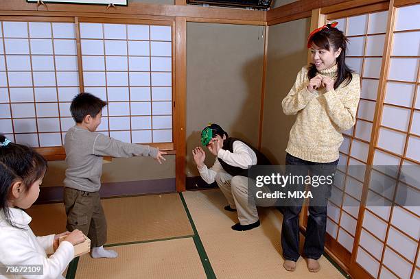 children throwing roasted beans for setsubun festival - 節分 ストックフォトと画像