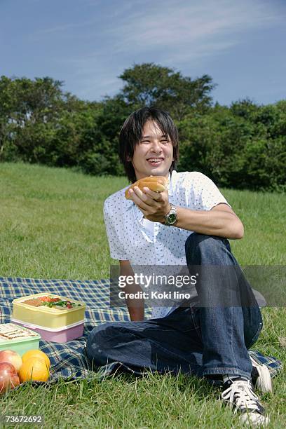 a young man eating hot dog - asian eating hotdog stock pictures, royalty-free photos & images