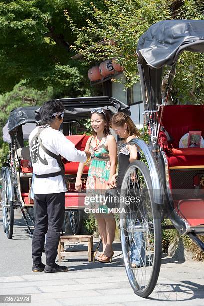 two young women talking with rickshaw driver - arashiyama ストックフォトと画像