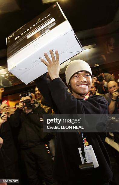 London, UNITED KINGDOM: Ritasu Thomas, aged 17, holds up his Playstation 3 in the Virgin Megastore, London on the day that Sony launches its...